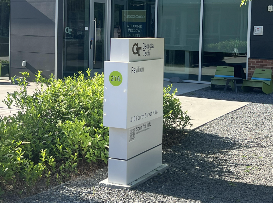 Georgia Tech Pavilion wayfinding sign outside a glass building entrance, displaying the Georgia Tech logo, building name, and street address.